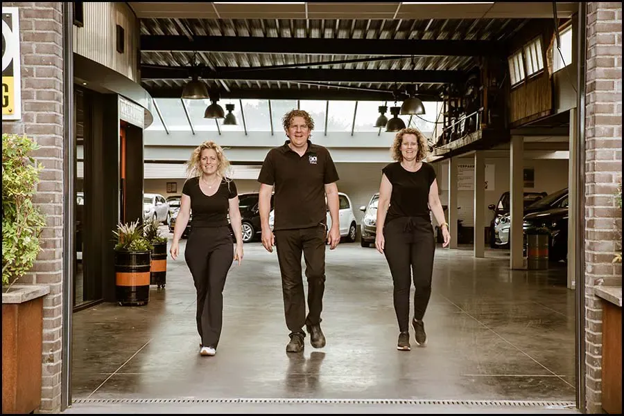 Drie medewerkers lopen door de werkplaats