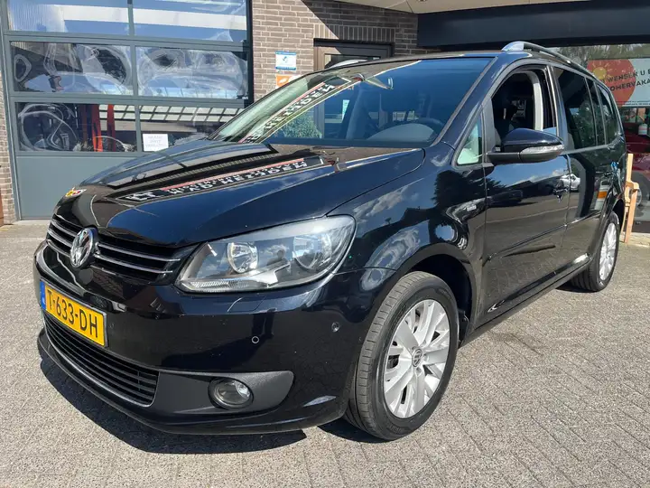 Volkswagen Touran 1.4 TSI Comfort voor het pand in Zijtaart
